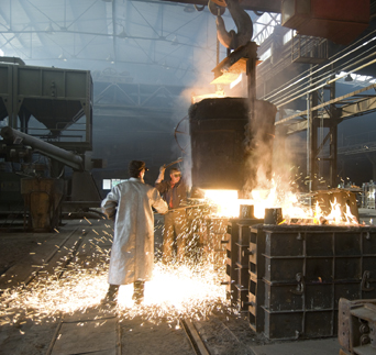 two men working with foundry ladle, sparks fly